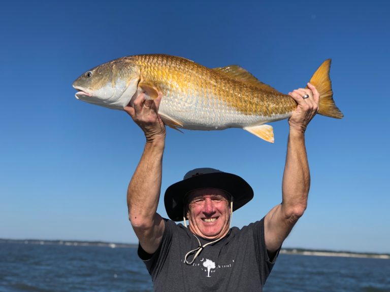Angler holding a redfish overhead