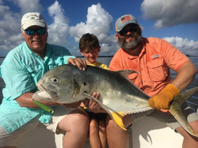 Father, son and friend holding a big jack crevalle aboard Lowcountry Cowboy
