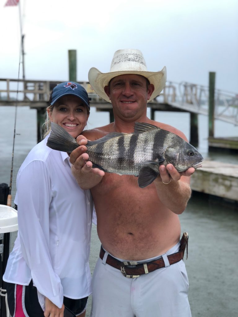 Couple holding a sheepshead on the dock