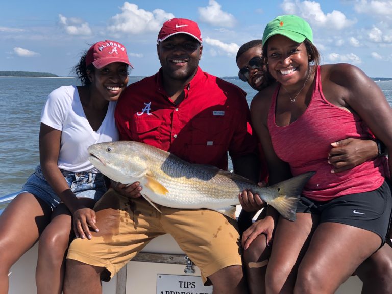 Four friends holding a redfish on a Hilton Head charter