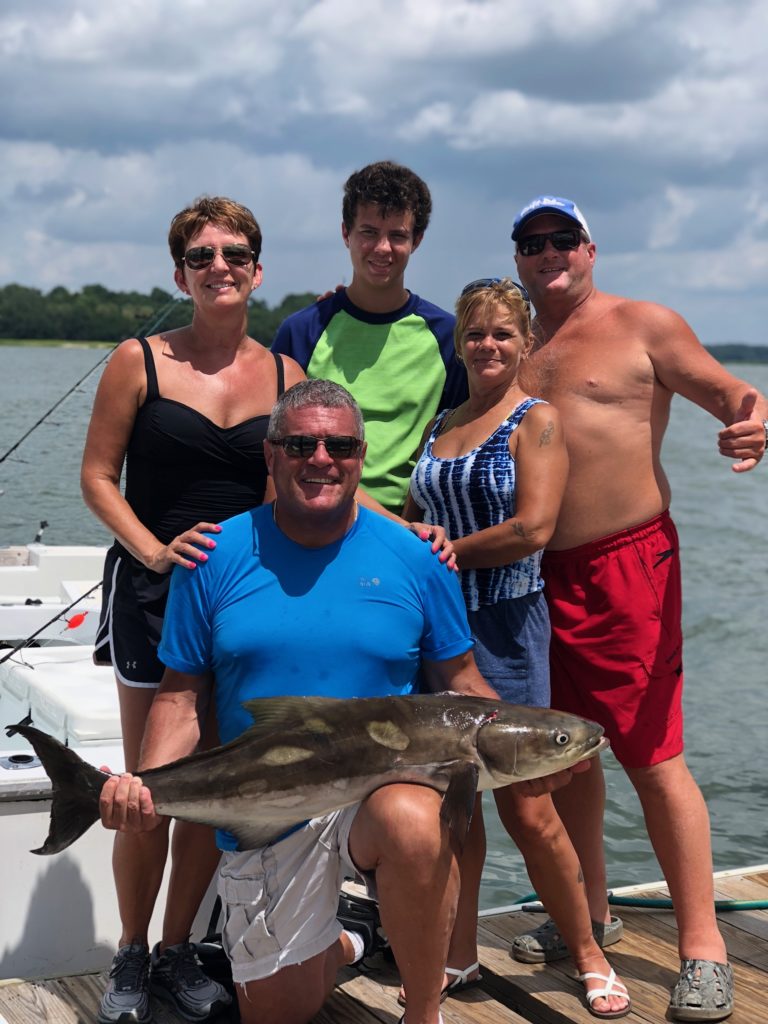 Family of anglers with their catch on the boat