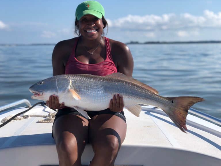 Angler holding a redfish on the bow